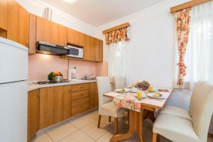 a kitchen and dining room with a table and chairs at Villas Rab Palit in Rab