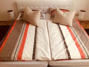 エアフルトにあるFerienwohnung Am Schmidtstedter Knotenのベッド(オレンジ&白の毛布、枕付)