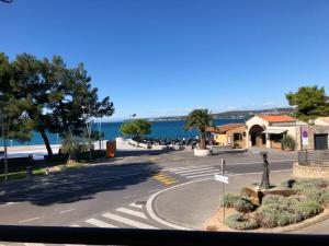 an empty street with a crosswalk in front of the ocean at Koper Sea Apartment in Koper
