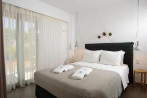 a bedroom with a bed with two towels on it at Pefkides in Marathopoli