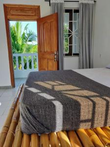 ein Schlafzimmer mit einem Bett mit einer Decke darauf in der Unterkunft Laughing Goat Ghana Hostel in Busua