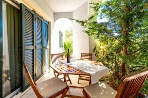 a patio with a table and chairs on a balcony at Villas Rab Palit in Rab