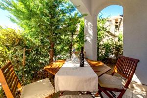 a table with a bottle of wine sitting on a patio at Villas Rab Palit in Rab