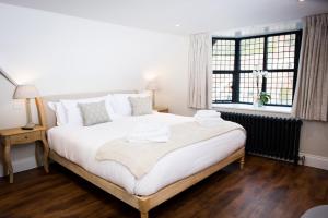 Un dormitorio con una gran cama blanca y una ventana en The Fox, en Winchester