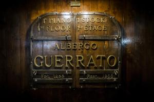 a sign on a wooden wall with writing on it at Hotel Guerrato in Venice