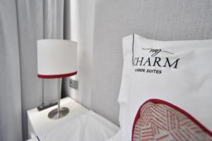 um quarto com uma mesa com um candeeiro e um saco branco em My Charm Lisbon Suites em Lisboa