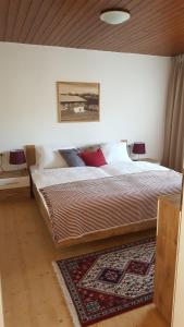 a bedroom with a large bed with a rug at Appartement Unterbergblick in Kössen