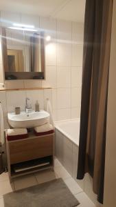 ein Badezimmer mit einem Waschbecken und einer Badewanne in der Unterkunft Appartement Unterbergblick in Kössen