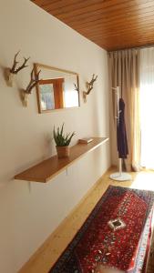 a room with a shelf and a mirror and a rug at Appartement Unterbergblick in Kössen