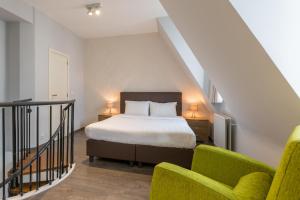 1 dormitorio con 1 cama y 1 silla en Thon Residence Florence Aparthotel, en Bruselas
