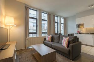 a living room with a couch and a kitchen at Thon Residence Florence Aparthotel in Brussels