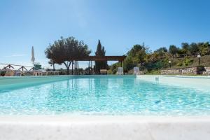 a large swimming pool with a gazebo at Farm stay Il Carro del Colle in Collevalenza +27 photos