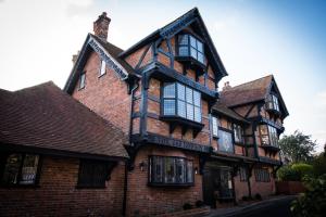 un antiguo edificio de ladrillo rojo con ventanas negras en The Fox en Winchester