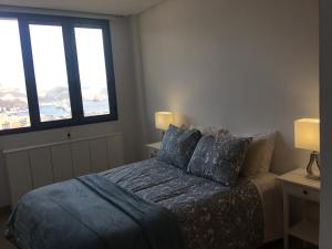 サンタクルス・デ・テネリフェにあるTower's Flat 2 on the 30th floor +wifi +digital tvのベッドルーム1室(青いシーツ付きのベッド1台、窓2つ付)