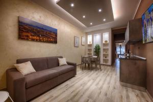 Una sala de estar con un sofá y una cocina. en TORINO VACANCY 3 - Elegant & Romantic house with a view of Piazza Vittorio/Gran Madre, en Turín