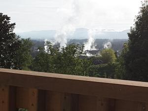 uma vista para um incêndio nas montanhas com fumo em Geyser Lookout BnB em Rotorua