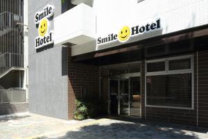 福岡的住宿－博多微笑酒店，大楼一侧微笑的酒店标志