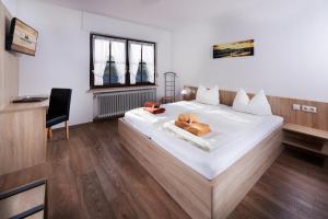 DrolshagenにあるGasthof Zum Hobelのベッドルーム(大きな白いベッド1台、椅子付)