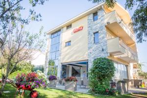 a hotel building with flowers in front of it at Pansion Glory in Međugorje