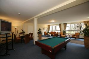 a living room with a pool table in a room at Seehotel Heidehof in Klein Nemerow