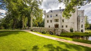una tenuta con un sentiero in pietra che conduce a un castello di Zamek Karpniki Schloss Fischbach a Łomnica