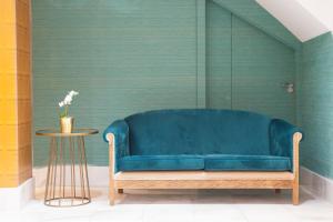 um sofá azul num quarto com uma mesa em Petit Palace Canalejas Sevilla em Sevilha