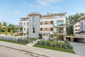 een wit gebouw met een hek ervoor bij Sopocka Bryza - Baltica Apartments in Sopot