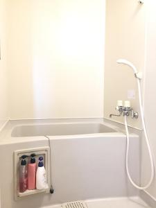 a bathroom with a bath tub with a shower at Park Hills in Kitami