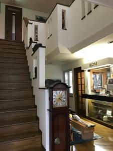 a clock in the middle of a room with stairs at Park Hills in Kitami