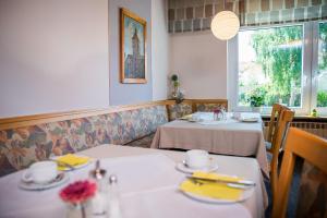 a dining room with two tables and a window at Hotel-Pension Seitz in Wolframs-Eschenbach