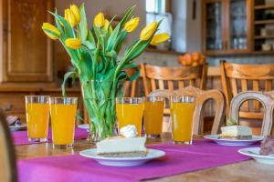 ザコパネにあるRent like home - Stroma 32Aの黄色い花とオレンジジュースのグラスを添えたテーブル