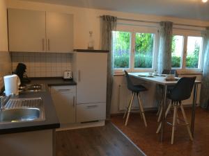 una cucina con lavandino e tavolo con sedie di Apartment Rietheim a Rietheim-Weilheim