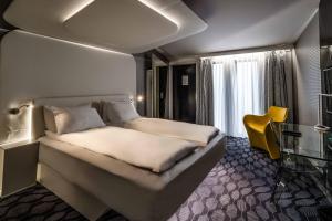 a hotel room with a bed and a yellow chair at Magic Hotel Korskirken in Bergen