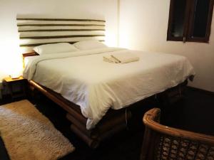 a bed with white sheets and towels on it at Vanpila in Savannakhet