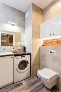 a bathroom with a washing machine and a sink at K&M Apartments in Warsaw