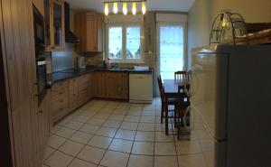 a kitchen with a table and a refrigerator at Maison de vacances à Kertzfeld in Kertzfeld +10 photos