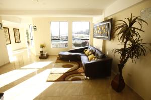 a living room with a black leather couch and a rug at La Mansion Casa Hotel in Andahuaylas