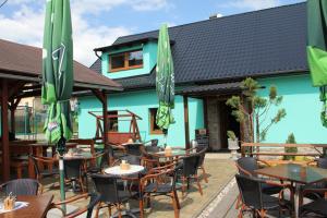 an outdoor restaurant with tables and chairs and umbrellas at Penzion Stará sokolovna in Šumperk