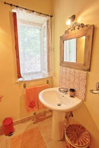 a bathroom with a sink and a mirror and a window at Kitrini Luxury Cottage in Zenempisátika