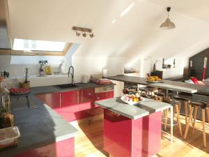 a kitchen with pink and black cabinets and a counter at Résidence du Parc avec Sauna in Eaux-Bonnes