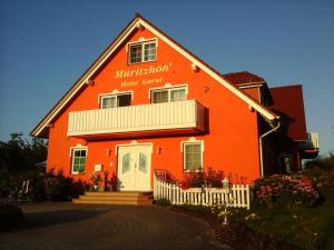 an orange building with a white fence in front of it at Müritzhöh in Rechlin