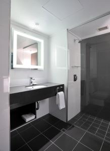 a bathroom with a sink and a mirror at Novotel Melbourne On Collins in Melbourne