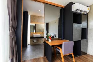Un comedor con una mesa y un espejo. en Sunnyvale Ranong 1, en Ranong 11 fotos más
