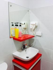 W łazience znajduje się umywalka i lustro. w obiekcie Cityscape Residences 1102 w mieście Bacolod