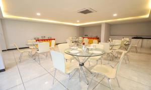 a dining room with tables and white chairs at Treebo Trend Apple Villa in Bangalore