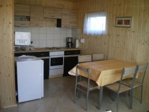 a kitchen with a table and chairs in a kitchen at Ferienhäuser mit Pool in Rewal