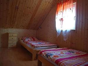 dwa łóżka w drewnianym pokoju z oknem w obiekcie Ferienhäuser mit Pool w Rewalu +12 zdjęć