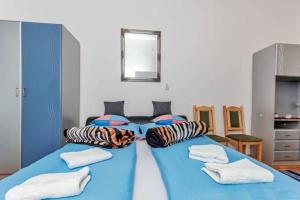 niebieskie łóżko z poduszkami w pokoju w obiekcie Arany Csillag Apartman w Egerze