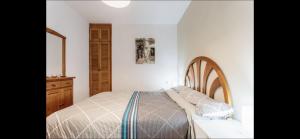 Un dormitorio con una cama y una cómoda de madera. en Daniela, en Puerto Naos