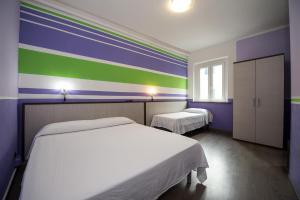 a bedroom with two beds and a colorful wall at Hotel Terranova in Pisa